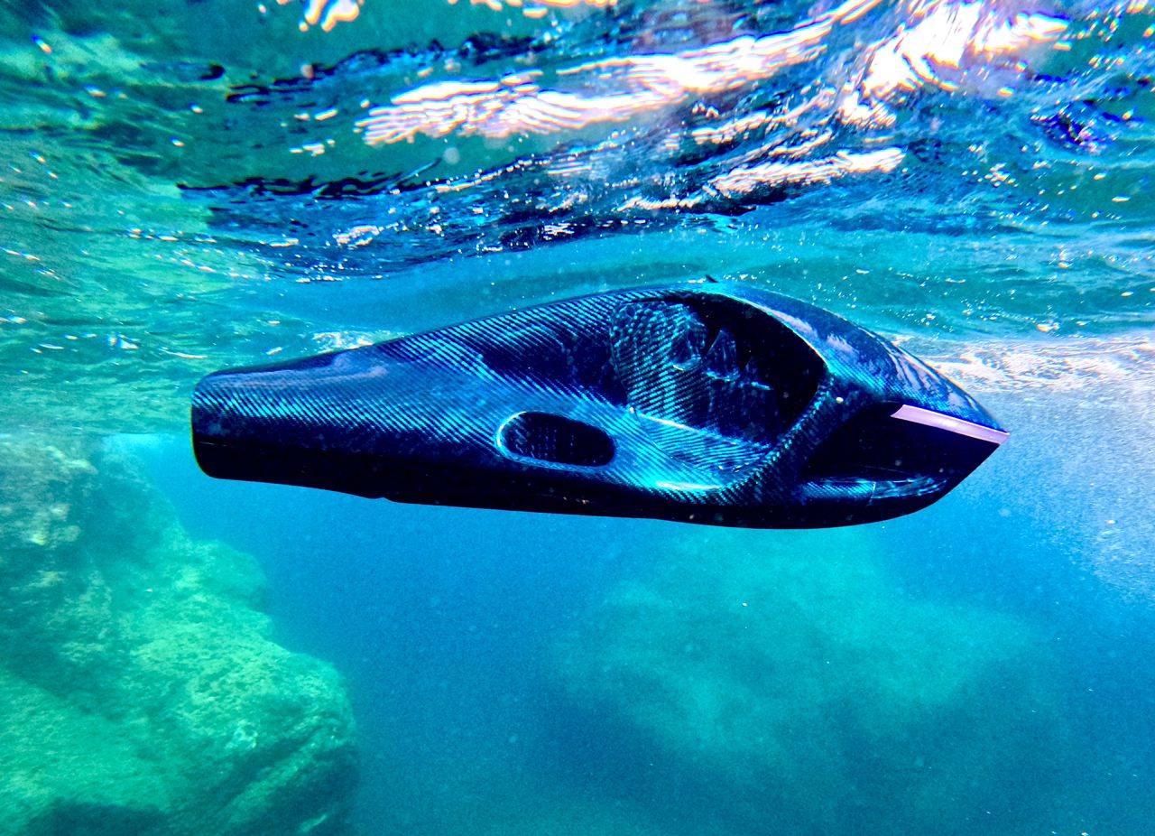 Snorkeler gliding through clear blue water with a sea scooter